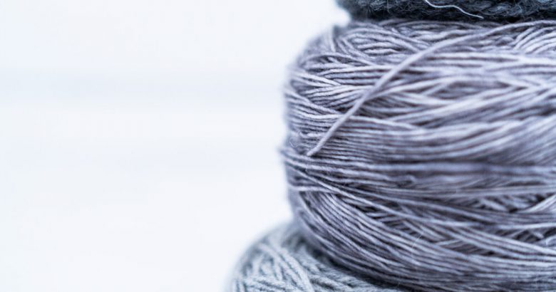 Image of three stacked blue/grey yarn cakes by Les Triconautes on Unsplash