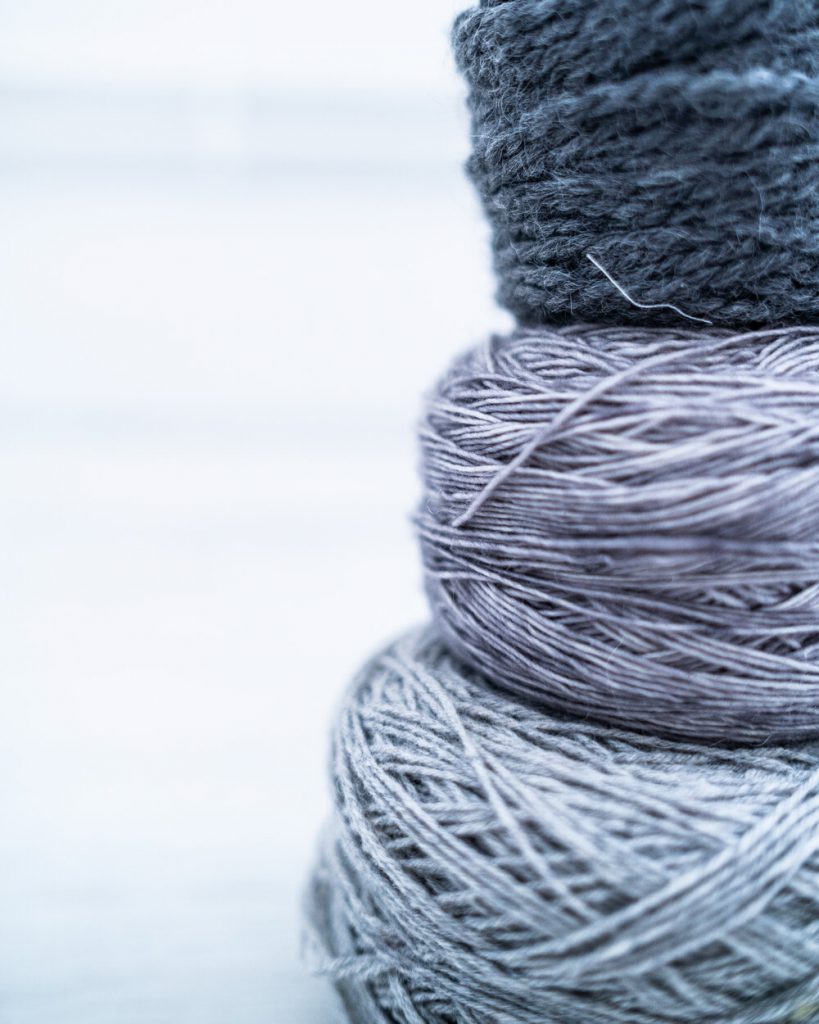 Image of three stacked blue/grey yarn cakes by Les Triconautes on Unsplash