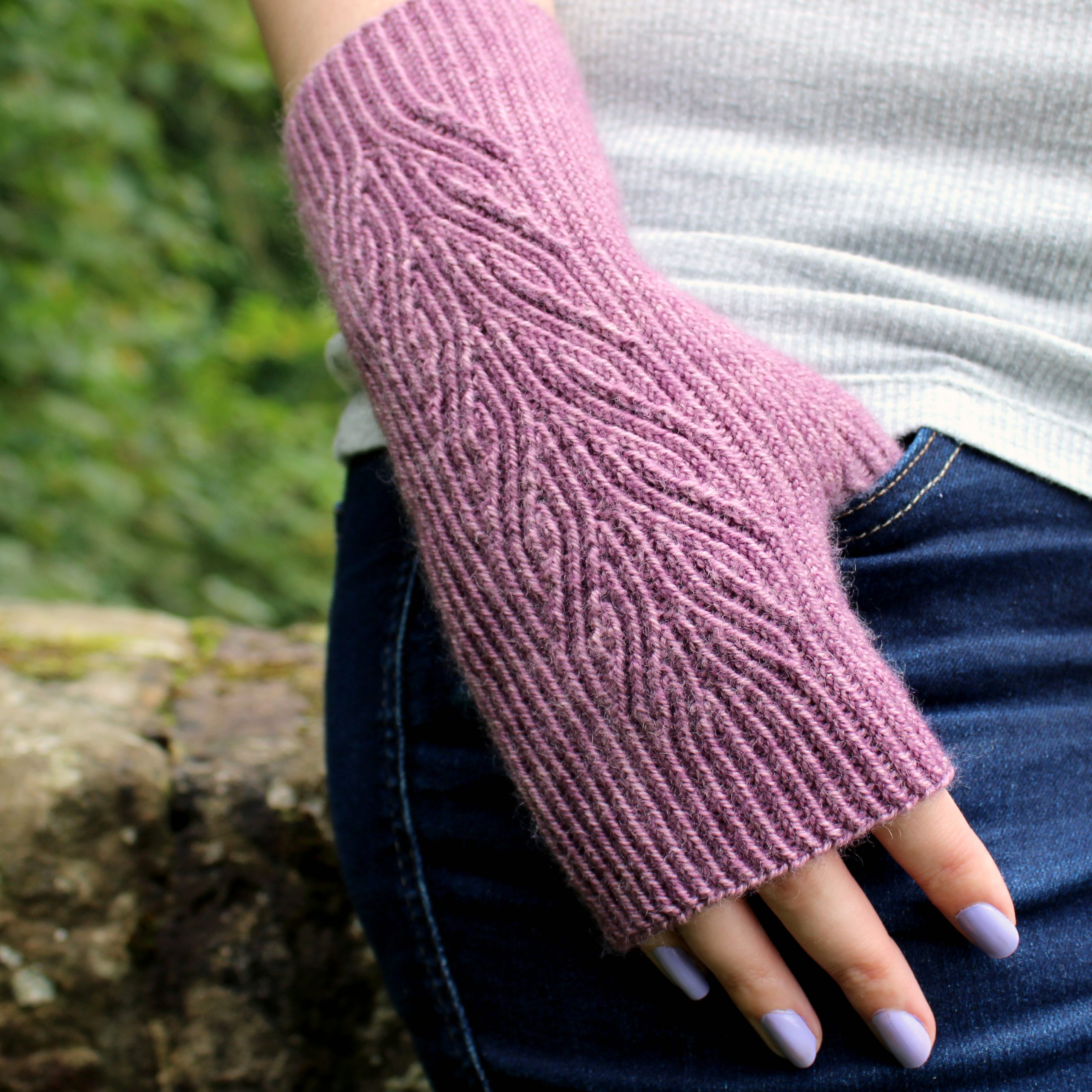 A purple fingerless mitt with a flowing faux cable pattern.