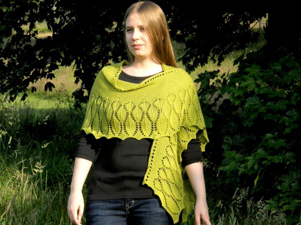 A green shawl with a feather patterned border