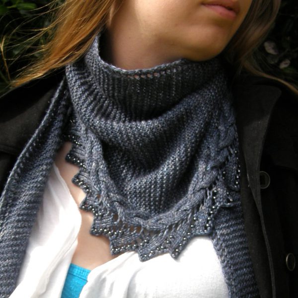 A shawl with a cabled, lace and beaded edge