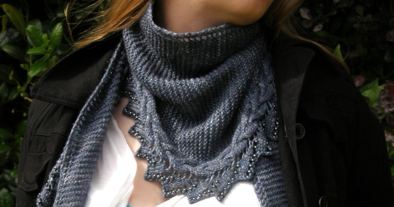 A shawl with a cabled, lace and beaded edge