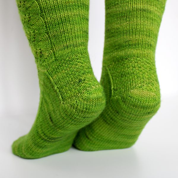 Green socks with a lace leaf pattern up the outside of the foot and leg