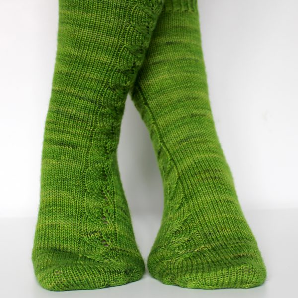 Green socks with a lace leaf pattern up the outside of the foot and leg