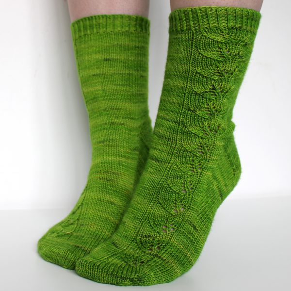 Green socks with a lace leaf pattern up the outside of the foot and leg