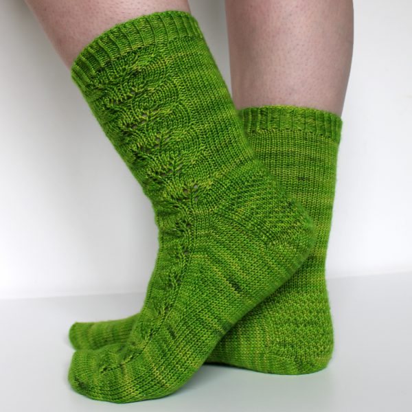 Green socks with a lace leaf pattern up the outside of the foot and leg