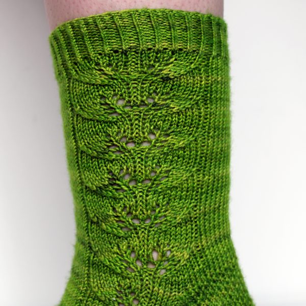 Green socks with a lace leaf pattern up the outside of the foot and leg