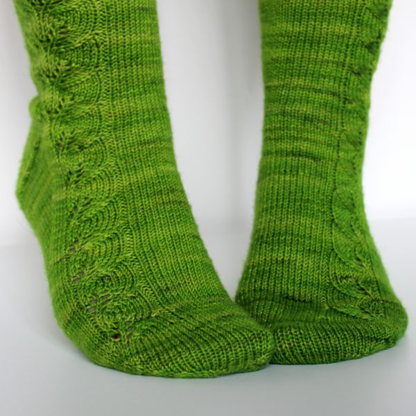 Green socks with a lace leaf pattern up the outside of the foot and leg