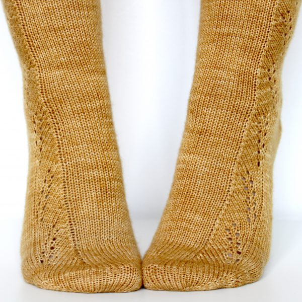 Golden socks with a lace wheat pattern up the outside of the foot and doubling at the leg