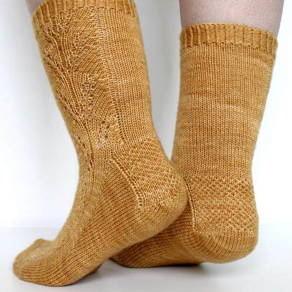 Golden socks with a lace wheat pattern up the outside of the foot and doubling at the leg