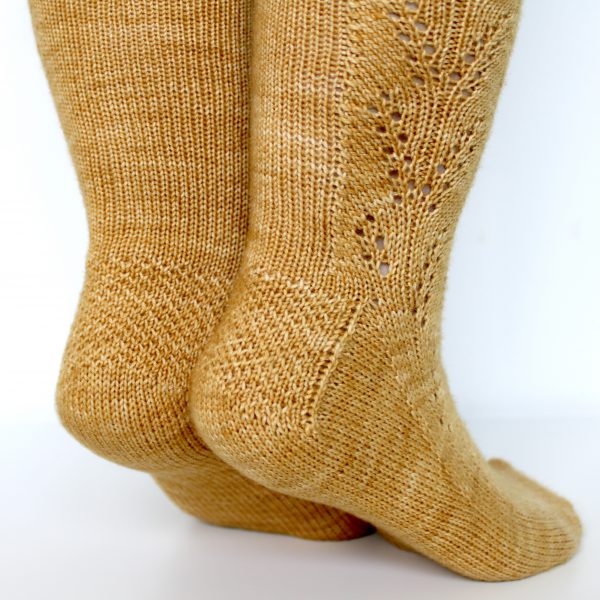 Golden socks with a lace wheat pattern up the outside of the foot and doubling at the leg