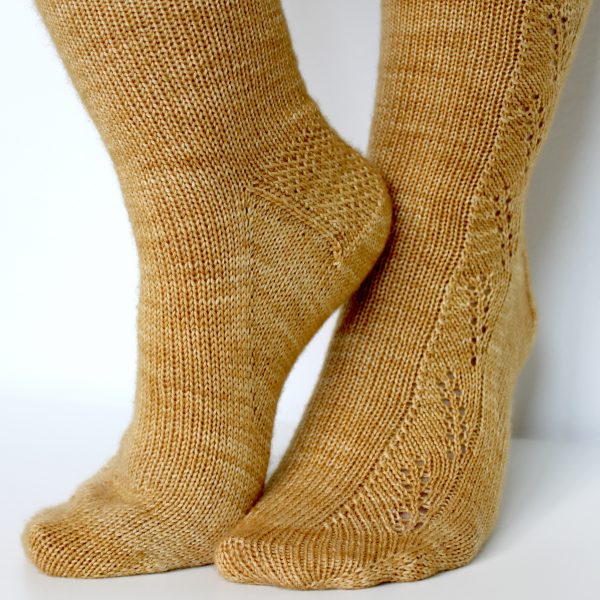 Golden socks with a lace wheat pattern up the outside of the foot and doubling at the leg