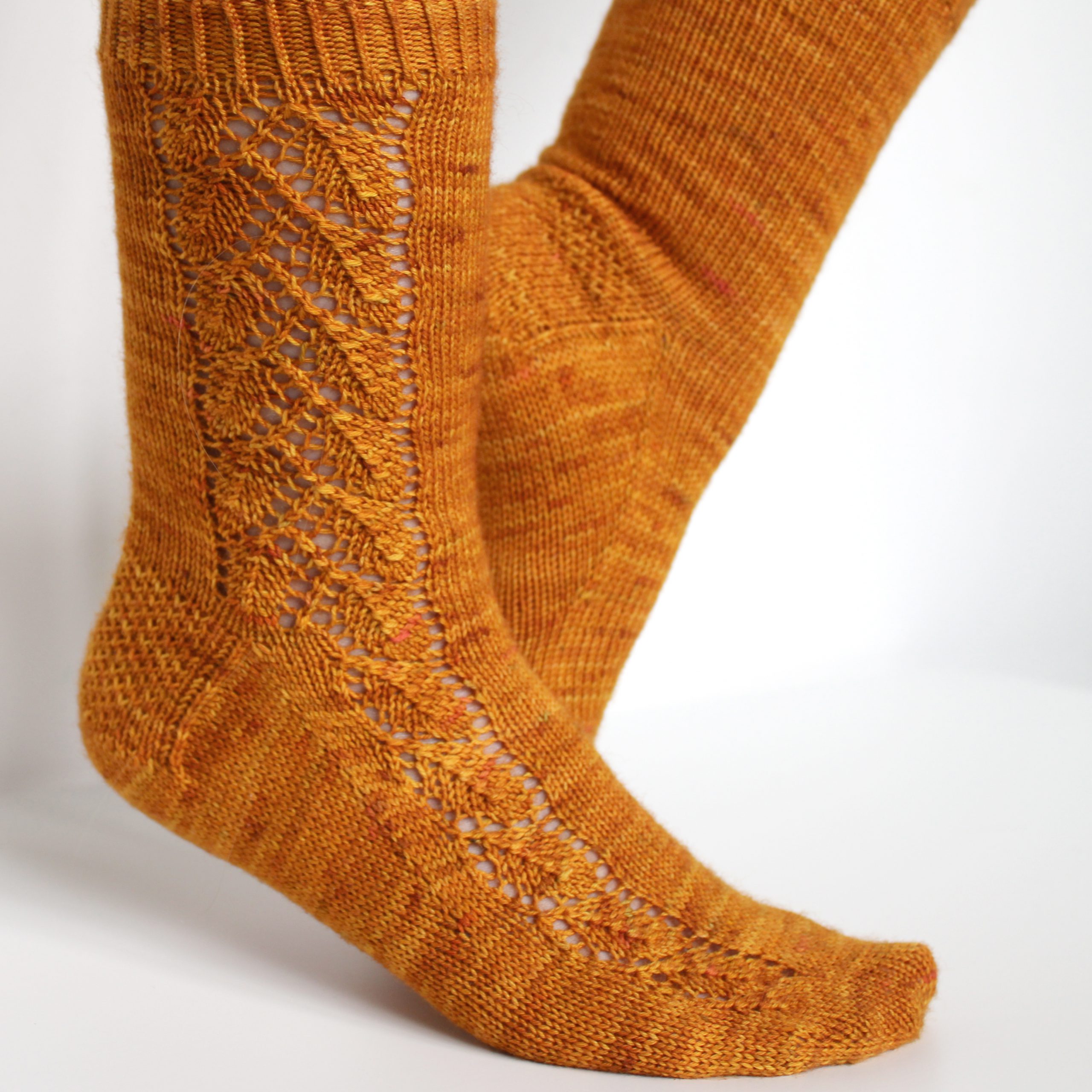 Orange socks with a lace leaf pattern up the foot and leg