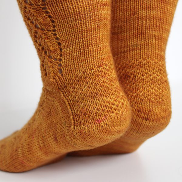 Orange socks with a lace leaf pattern up the foot and leg