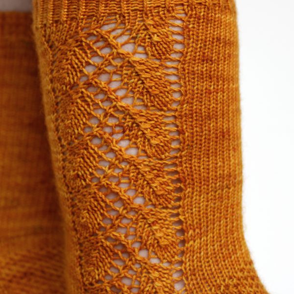 Orange socks with a lace leaf pattern up the foot and leg