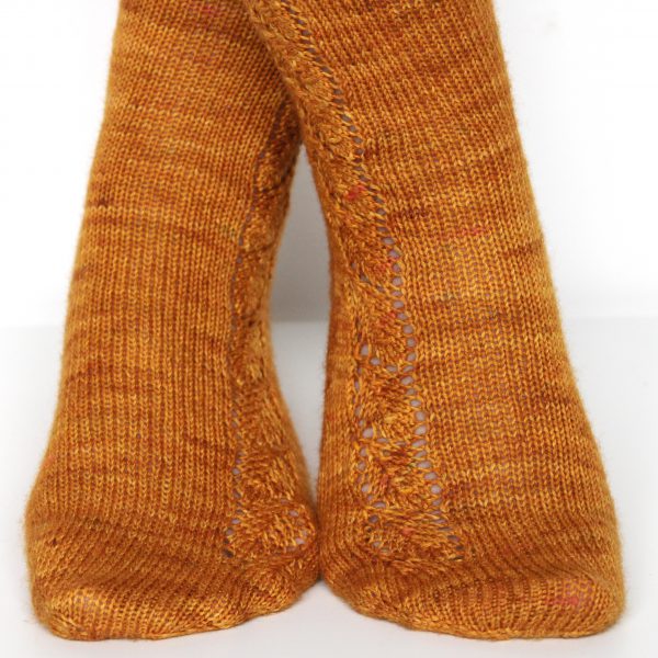 Orange socks with a lace leaf pattern up the foot and leg