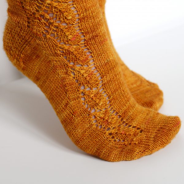 Orange socks with a lace leaf pattern up the foot and leg