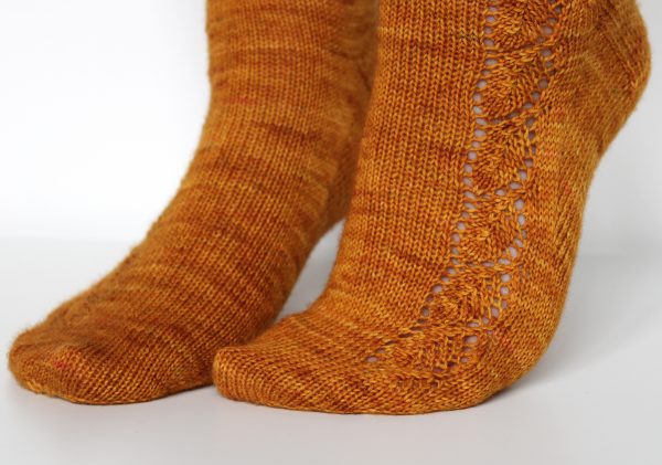 Orange socks with a lace leaf pattern up the foot and leg