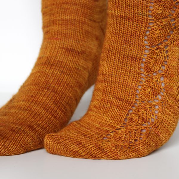 Orange socks with a lace leaf pattern up the foot and leg