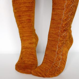 Orange socks with a lace leaf pattern up the foot and leg