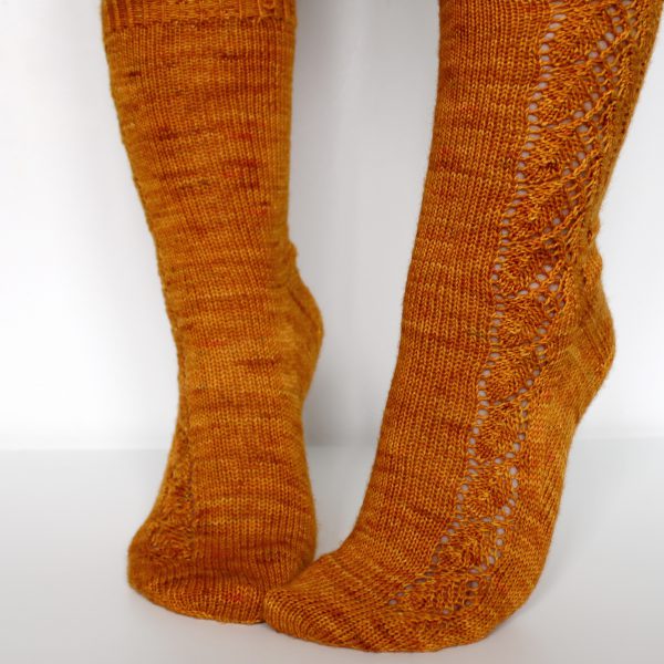 Orange socks with a lace leaf pattern up the foot and leg