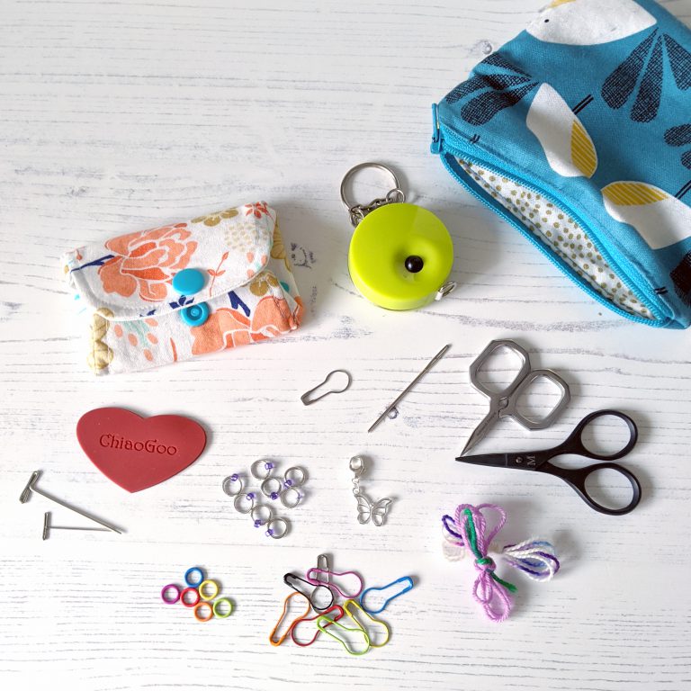 Notions pouches, tape measure, scissors, scrap yarn and a selection of stitch markers
