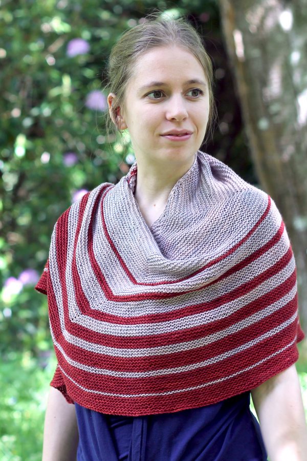 A crescent shaped shawl with graduated strips towards the edge