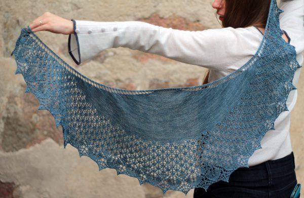 A crescent shawl with a stockinette body and wide lace section