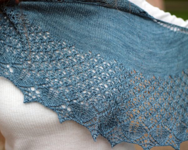 A crescent shawl with a stockinette body and wide lace section