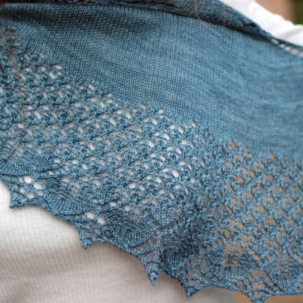 A crescent shawl with a stockinette body and wide lace section