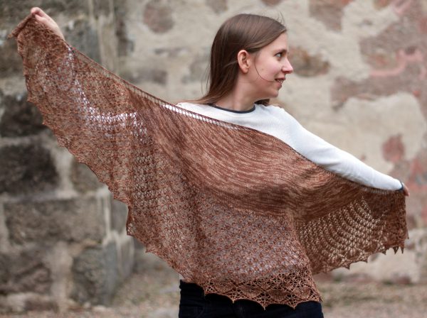 A crescent shawl with a stockinette body and wide lace section