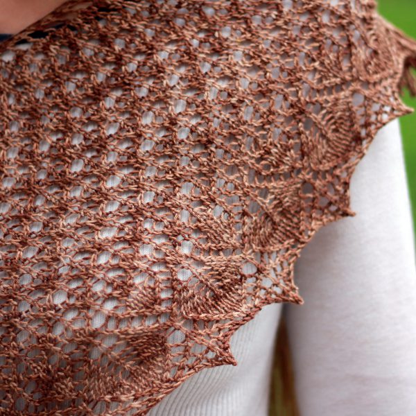 A crescent shawl with a stockinette body and wide lace section