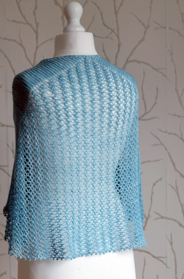 A crescent shaped shawl with a central lace mesh panel and two garter stitch sections