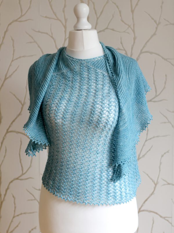 A crescent shaped shawl with a central lace mesh panel and two garter stitch sections