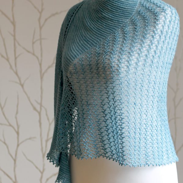 A crescent shaped shawl with a central lace mesh panel and two garter stitch sections