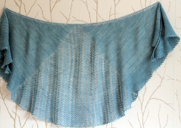 A crescent shaped shawl with a central lace mesh panel and two garter stitch sections