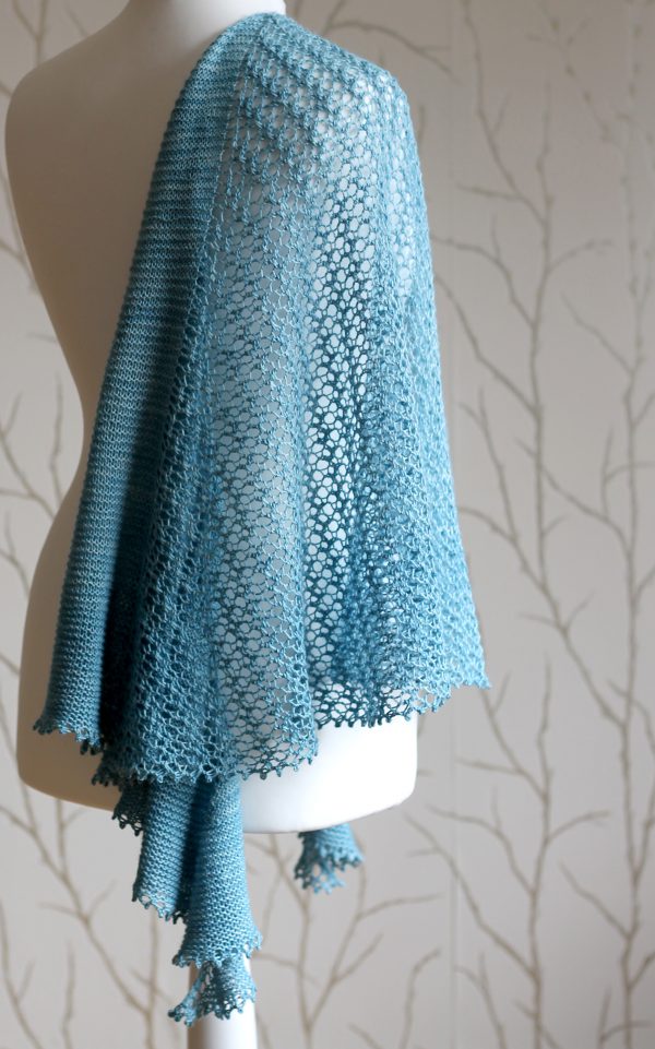 A crescent shaped shawl with a central lace mesh panel and two garter stitch sections