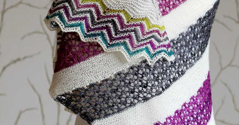 A shawl with coloured lace stripes and chevron border