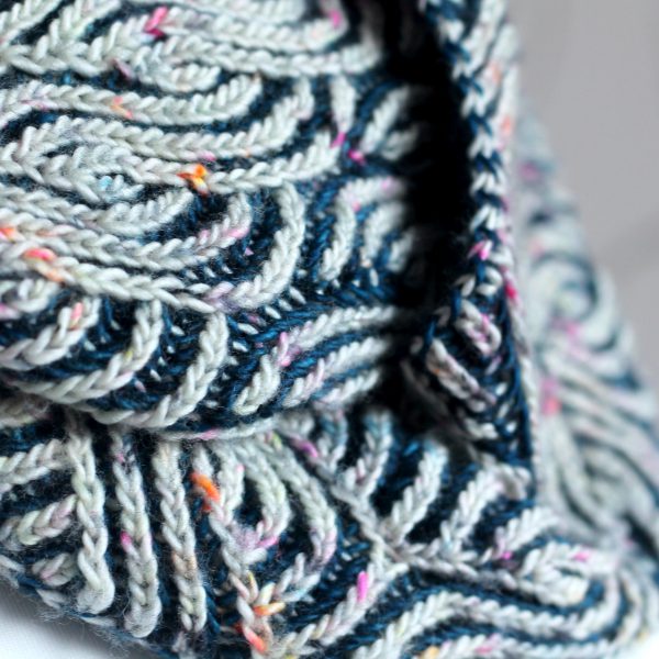 A close up on a long brioche cowl wrapped twice around a mannequin