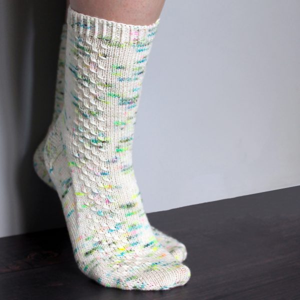 A pair of speckled socks with a column of textured pattern up the outside of the foot