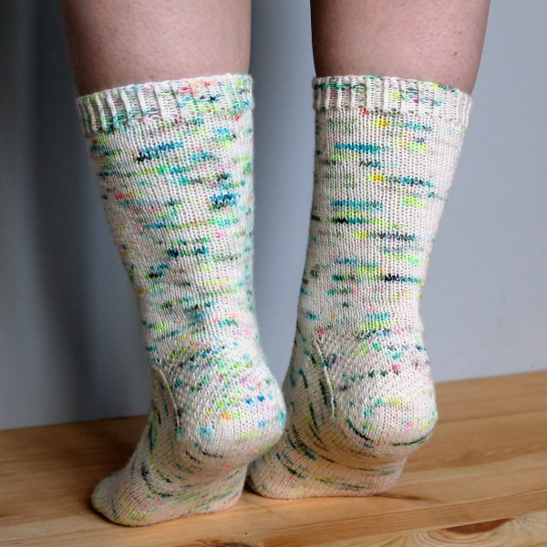 A pair of speckled socks with a column of textured pattern up the outside of the foot