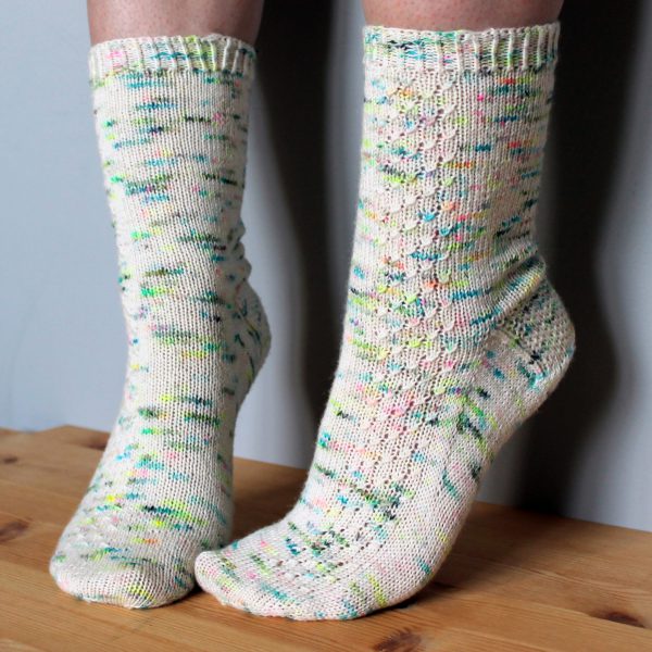 A pair of speckled socks with a column of textured pattern up the outside of the foot