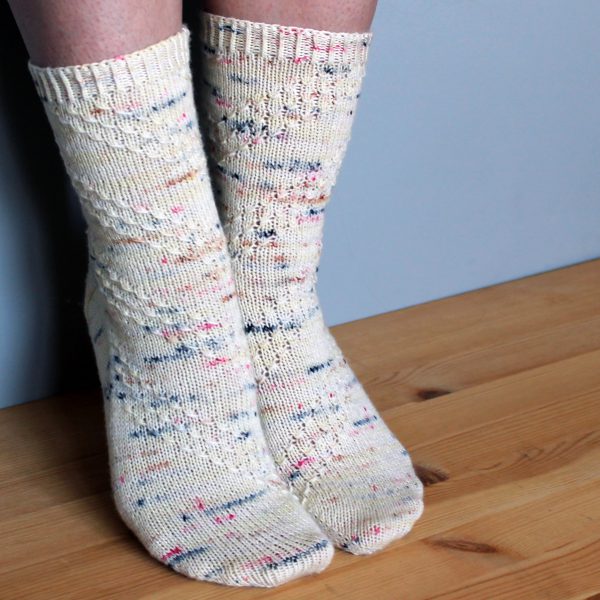 A pair of socks with a textured diagonal stripe mirrored on each foot