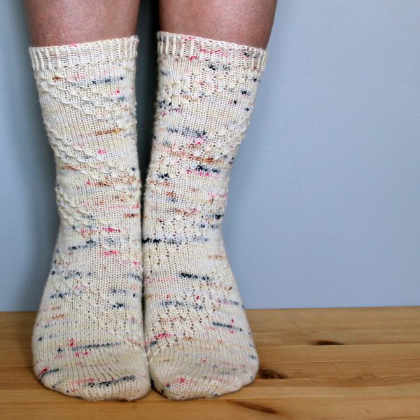 A pair of socks with a textured diagonal stripe mirrored on each foot