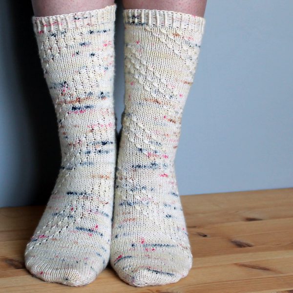 A pair of socks with a textured diagonal stripe mirrored on each foot