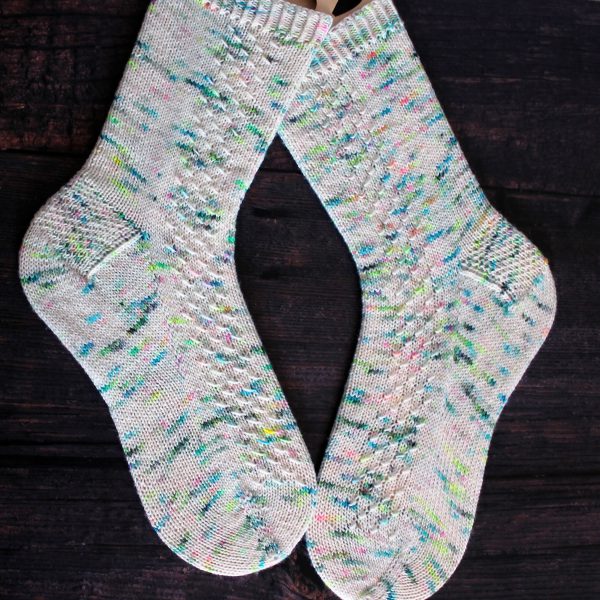 A pair of speckled socks with a column of textured pattern up the outside of the foot