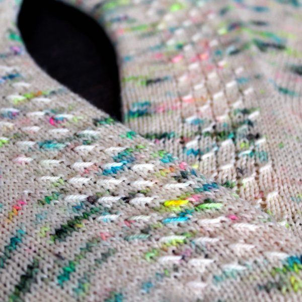 A pair of speckled socks with a column of textured pattern up the outside of the foot