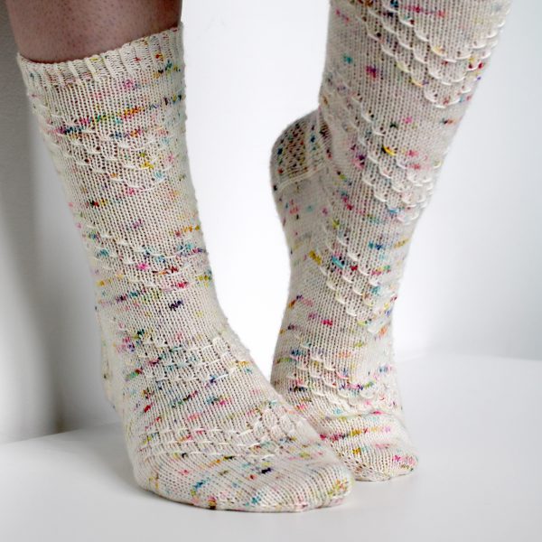 A speckled pair of socks with a textured chevron pattern