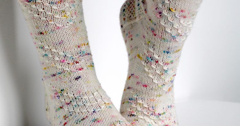 A speckled pair of socks with a textured chevron pattern