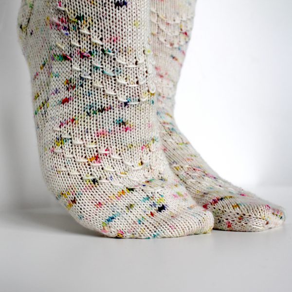 A speckled pair of socks with a textured chevron pattern